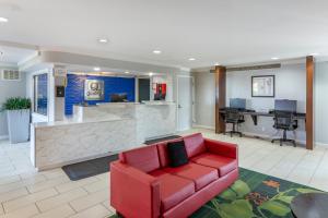 a lobby with a red couch and a bar at Quality Inn Fayetteville near Fort Bragg in Fayetteville