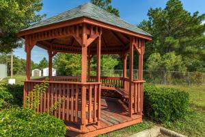 a wooden gazebo with a roof in a yard at Quality Inn Near Fort Liberty formerly Ft Bragg in Fayetteville