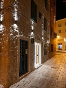 un callejón con una puerta en un edificio de piedra por la noche en ST. CLARA OLD TOWN, en Šibenik
