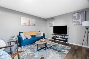 sala de estar con sofá azul y TV de pantalla plana en Lovely 3 Bedroom Colonial home en Middletown