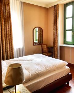 een slaapkamer met een bed, een spiegel en een lamp bij Hotel Roma in Sestola