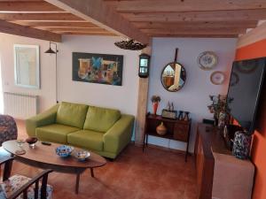 un soggiorno con divano verde e tavolo di Sotam Country House EN342 a Góis