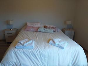 Una cama con dos toallas encima. en Casa ideal para descansar a 20 min de Bariloche en Dina Huapi