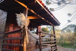 a hammock on the porch of a log cabin at Cabana na Floresta Rincão do Fortaleza in Cambará