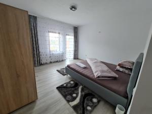 a small bedroom with a bed and a window at Agropensiunea Maya-Andrei in Bumbesti Pitic