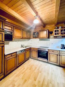 a large kitchen with wooden cabinets and wooden floors at Blockhaus Semmering in Steinhaus am Semmering