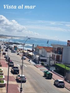 a city street with cars parked on the beach at Guzmán in Punta del Este