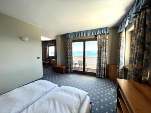 a bedroom with a bed and a view of the ocean at PanoramaHotel Penegal in Mendola