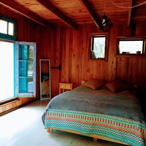 a bedroom with a bed in a wooden room at Los Lirios in Los Hornillos