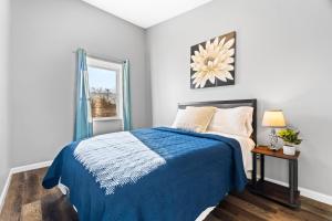 a bedroom with a bed with a blue blanket and a window at Lovely 3 Bedroom Colonial home in Middletown