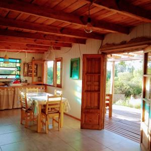 a kitchen and dining room with a table and chairs at Los Lirios in Los Hornillos