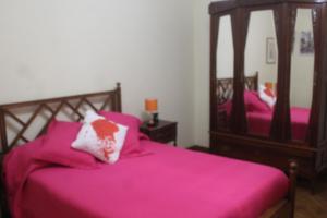 um quarto com 2 camas com lençóis cor-de-rosa e espelhos em Boa Vivenda em Carcavelos