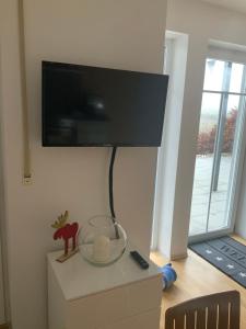 a tv on top of a dresser with a fish bowl at Apartment „Am Südhang“ in Adelzhausen
