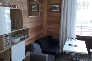 salon z niebieskim krzesłem i stołem w obiekcie STUDIO 2 PERS PLEIN CENTRE VAL CLARET w mieście Tignes