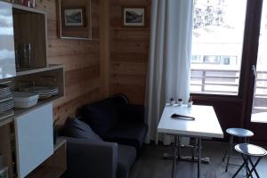 salon ze stołem, krzesłem i oknem w obiekcie STUDIO 2 PERS PLEIN CENTRE VAL CLARET w mieście Tignes