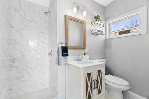 a bathroom with a toilet and a sink and a mirror at Lovely 3 Bedroom Colonial home in Middletown
