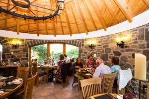 um grupo de pessoas sentadas em mesas em um restaurante em Errichel House and Cottages em Aberfeldy