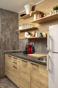 a kitchen with wooden cabinets and a white refrigerator at Apartment Viksa with Jacuzzi in Zagreb