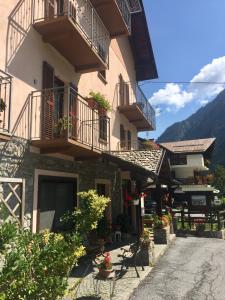 un edificio con balcones y flores en una calle en Alloggi Il Rododendro, en Bagni di Vinadio