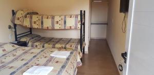 a room with two bunk beds and a hallway at Nuevo Hotel Magnet in Villa Carlos Paz