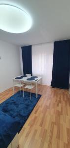 a room with a table and a blue rug at Casa Rusu - Govandari -Self check in-24h in Reşiţa