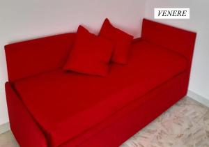 um sofá vermelho com almofadas vermelhas num quarto em Il Rifugio di Bacco e Venere em Pietrapertosa