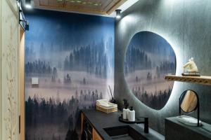 a bathroom with a large painting of trees on the wall at Apartament Dream&Snow in Zakopane