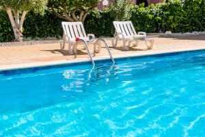 two white chairs sitting next to a swimming pool at Apartment Brisbane by Algarve Vacation in Albufeira