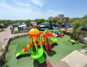 uma vista aérea de um parque infantil com escorregas e passeios em Camping Tredue em Sottomarina
