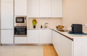 a kitchen with white cabinets and a sink at Villa Agape Luxury Leuca by HDSalento in Leuca +22 photos