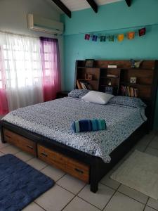 a bedroom with a bed with a wooden headboard at Orrie's Beach Bar and Hotel in Crab Hill