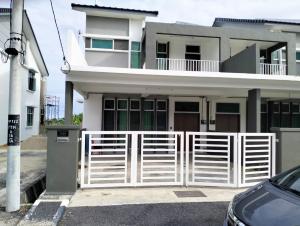 a white fence in front of a house at Mahzan Homestay in Jitra