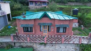 ein Modell eines Hauses mit grünem Dach in der Unterkunft SKY TOUCH COTTAGES AND STAYS UNIT 2 in Mukteswar