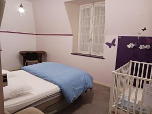 una camera da letto con una culla con coperta blu di chateau du ponthereau a Massay