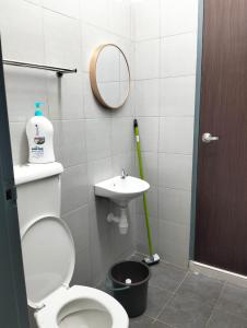 a bathroom with a toilet and a sink and a mirror at Mahzan Homestay in Jitra