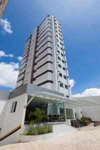 a tall white building with a glass facade at Rede Andrade Hangar in Belém