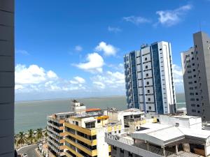 vistas a una ciudad con edificios y al océano en Flat number one temporadalitoranea en São Luís