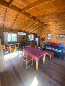 a room with a table and a couch in a cabin at Cabaña Magnolia en Marea Delta del Tigre in Tigre