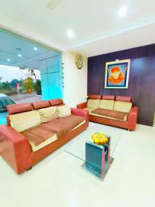 a living room with two beds and a couch at SAI SRUSHTI by NEEM SQUARE in Shirdi