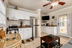 a kitchen with white cabinets and a stainless steel refrigerator at Walkable to Restaurants and Steps to the Beach! - Coconut Villa's Suite 10 in St. Pete Beach