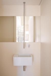 ein Badezimmer mit einem weißen Waschbecken und einem Spiegel in der Unterkunft Casa do Macau in Monção