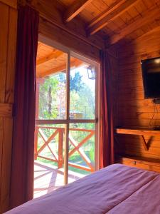 1 dormitorio con una ventana que da a un porche en Cabaña Magnolia en Marea Delta del Tigre en Tigre