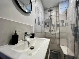 ein weißes Bad mit einem Waschbecken und einer Dusche in der Unterkunft Promenades / 1 Chambre / Neuf in Roanne