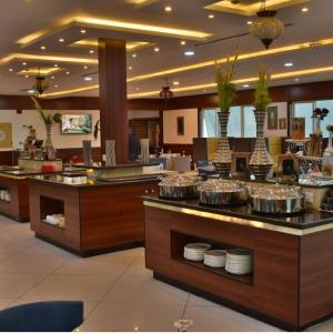 a restaurant with a buffet with dishes on display at The District Hotel Najran in Najran