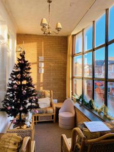 a living room with a christmas tree in a room with windows at Kings Court Hotel in Blackpool