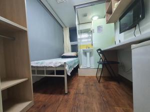 um pequeno quarto com uma cama e um lavatório em Apgujeong Home em Seul