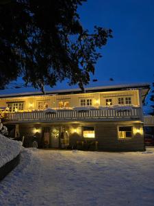 a building with lights on in the snow at night at Hyggelig leilighet i sentrum in Hemsedal