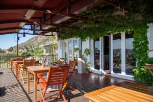 a row of tables and chairs on a deck at Casa Alta Hotel Boutique & Spa - Solo Adultos in Villa Carlos Paz