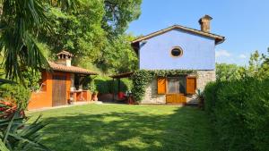 mały domek z zielonym ogródkiem przed nim w obiekcie villa la chiesetta - private pool w mieście Fabriano