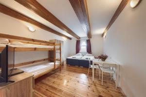 a room with two bunk beds and a table at Hostel Białystok Centrum in Białystok